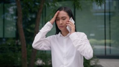 Endişeli Koreli Koreli Japon kadın, kız iş kadınını üzdü. Cep telefonuyla konuşan iş kadını. Kötü haber.