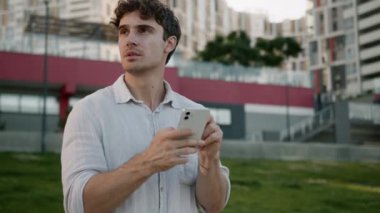 Düşünceli Kafkasyalı adam cep telefonu kullanıyor. Akıllı adam düşünüyor. GPS navigatörüne bakıyor. Çevrimiçi erkek işadamı iş dünyası açık hava çözümleri işveren sorunu.