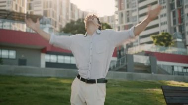 Beyaz dansçı genç adam taşınmayı kutluyor enerjik müzik dinliyor erkek iş adamı şehir dışında eğleniyor dans zaferi kazanıyor iyi ruh hali kentsel iş kaygısız olsun