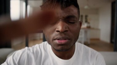 Afrikalı adam POV cep telefonuyla dokunmatik ekranı kullanarak sosyal medyayı kaydırıyor erkek blogcu cihaz bağımlısı evde yazı yazarken internete girip şaşkın bir şekilde şok geçiriyor.