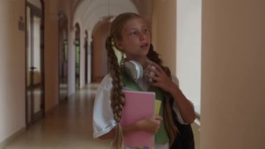 Kafkas ergen liseli kız öğrenci okul koridorunda yürüyor üniversite koridorunda eğitim görüyor çocuk kitapları tutuyor çocuk okula gidiyor akademide öğrenim görüyor.