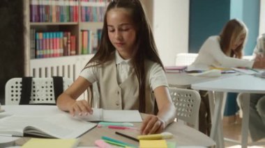 Beyaz kız öğrenci öğrenci öğrenci öğrenci kız öğrenci ilkokul çocuğu ilkokul eğitimi ödevi sınavı yazma tatminsiz baş parmak işaret parmağı kötü öğrenim kütüphanesi çalışmasından hoşlanmıyor.