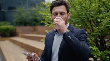 İş adamı sabah kahve molası verir Kafkasyalı erkek iş adamı profesyonel orta yaşlı girişimci şehir dışında içmenin tadını çıkartır cep telefonu kullan