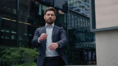 İş adamı Kafkasyalı resmi takım elbiseli adam iş adamı yatırımcı yatırımcı tüccar el ele tutuşup şehir merkezindeki kameraya bakan kendine güvenen erkek emlakçı şehir mimarı pozu verdi.