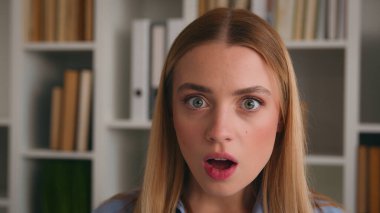 Şok olmuş kadın yüzü büyük gözler açık ağız portresi hayret verici hayret verici hayret verici yönetici bayan öğrenci kız kütüphanede Kafkasyalı kadın beklenmedik haber şoku işkadını şaşırttı