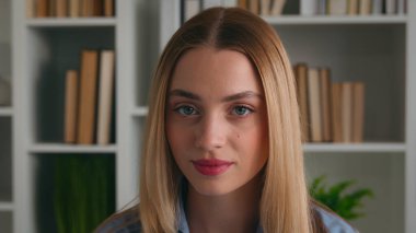 Üniversite kütüphanesinden mezun olan zeki beyaz kız öğrenci üniversite dersi. Ev işyerindeki kameraman iş kadınına bakıyor. İş kadını içeride, kitaplık vesikalığı ile fotoğraf çekiyor.