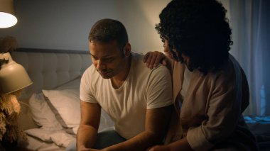 Afro-Amerikalı üzgün adam, gece yatağında oturup üzüntüden kahroluyor. Ereksiyon bozukluğu çeken, sevgi dolu kadın. Rahatlatıcı destek veren empati krizi, iktidarsızlık sorunu, iktidarsızlık sorunu.