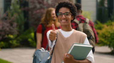 Üniversite kampüsünün yakınında konuşan Afro-Amerikan mutlu öğrenci kız öğrenci kız öğrencilerin sınıf eğitiminden sonra iyi bir lise bilgisi ile jest yapmalarını tavsiye ederim.