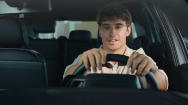 Otomobil salonu bayiliğinde yeni lüks elektrikli taşıt kullanan mutlu beyaz adam, mutluluğun kredi borçlarını satın alan müşterinin kredi kartı duygularına ulaşmasını kutluyor.