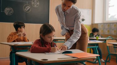 Sınıf ders çocukları, sınıfta öğrenim gören bayan öğretmen, yürüyüş yapan öğretmen, küçük çocuk, el ele tutuşan çocuk, soru soran çocuk, cevap veren, öğrenen, konuşma eğitimi alan.
