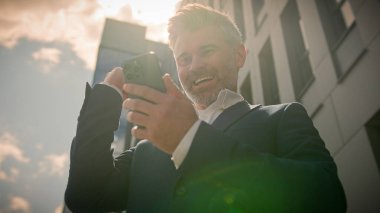 Kafkasyalı mutlu, mutlu, orta yaşlı iş adamı gezici zaferini kutluyor. Heyecanlı, sevinçli, üst düzey yönetici iş adamı. İyi haberler alıyor.