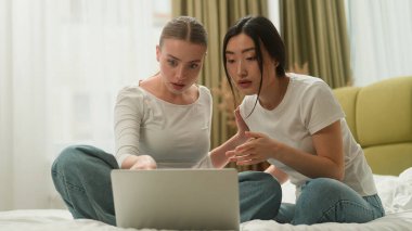 İki çok ırklı kadın üzgün üzgün arkadaşları, endişeli kadın çeşitliliği, beyaz kadın Asyalı kız birlikte yatak odası öğrencileri arkadaşlığı, dizüstü bilgisayar arızası, kötü haber.