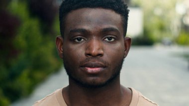 Melez, ciddi, etnik bir erkeğin şehirde gülümseyen Afrikalı Amerikalı bir adama bakması mutlu bir parmak göstermesi iyi bir hareket.