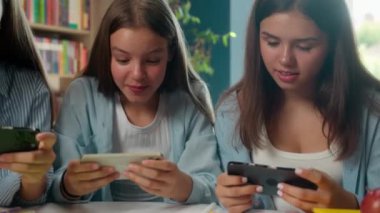 Kafkasyalı dört arkadaş, öğrenci, ergen erkek, erkek kız, video oyunu oynayan kız, erkek, cep telefonu, akıllı telefon bağımlılığı, okul kütüphanesinde sorun bağımlılığı üzerine çalışıyor.