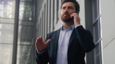 Duygusal gülümseme, orta yaşlı, orta yaşlı, yetişkin, erkek, işveren, iş adamı, danışman, girişimci, cep telefonuyla konuşan, şehir merkezinde akıllı telefonlardan bahseden.