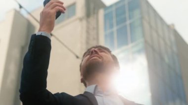 Orta yaşlı, beyaz erkek, erkek, iş adamı, iş adamı, şehir merkezindeki iş adamı, güneşli şehir merkezinde cep telefonu sinyali bulmaya çalış, kablosuz internet, yüksek çözünürlüklü, sorunlu telefon konuşmaları.