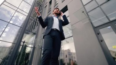 Alt görünüm orta yaşlı beyaz erkek, erkek, iş adamı, işveren, şehir ofisine gidiyor cep telefonundan konuşuyor iş danışmanlığı müşterileri, akıllı telefon görüşmeleri konuşuyor.