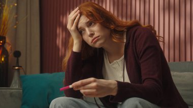 Evde üzgün hamile bir kadın, hamilelik testinin pozitif ya da negatif sonuçlanacağını vurguladı. Müstakbel anne endişeli, sağlıksız sağlık sorunları, kürtaj, kısırlık, sağlık hizmetleri...