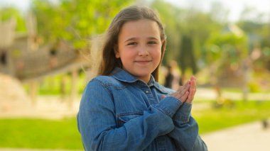 Açık havada sevimli mutlu bir çocuk beyaz bir kız çocuğu evlat edindi velayet çocuğu gülümsedi genç bir kız öğrenci kameraya bakıp el çırptı alkışlar alkışlar şehirde tebrik eder