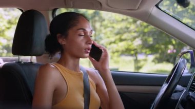 Ciddi Afrika kökenli Amerikalı kadın sürücü otomobil taşıma aracı. Telefona cevap veren akıllı telefon. Çalışan kadın girişimci.