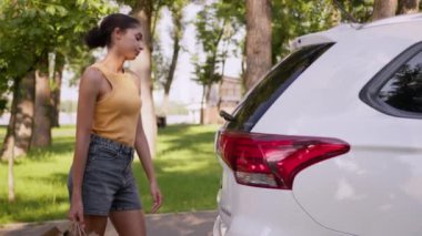 Yorgun, Afro-Amerikalı bir kadın araba teslimatı, bagajlar, paketler, kadın alıcılar, alışveriş işkadınları, otomobil nakliyecileri, müşteriler, açık hava işleri...