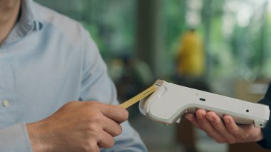 Müşteri yemek siparişini kafede öder tanınmayan adam NFC 'de telefon garsonunun restoranda ziyaretçiye servis ettiği erkek adam banka uygulaması mobil servis nakitsiz taraması yapıyor.