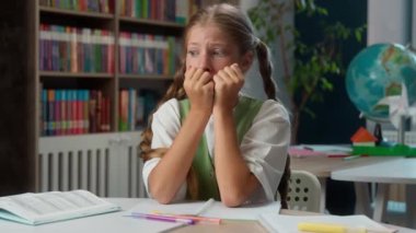 Endişeli, endişeli, küçük, beyaz kız, korkmuş, korkmuş, okul çocuğu, gergin öğrenci, ilkokul öğrencisi, tırnak yiyen, sınavda başarısız olmaktan korkan, endişelenen, sınıf sorunları.