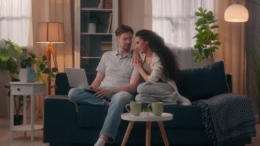 Gülümseyen mutlu, çok ırklı çift, erkek, erkek, erkek, erkek, erkek, Latin, kadın, kadın, kız, kız arkadaş bilgisayar alışverişi yapan erkek arkadaş, evde dizüstü bilgisayarları tartışıyorlar.