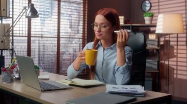Kafkasyalı kadın iş kadını bayan yönetici iş adamı molada çay fincanı içerek ellerinde fincanla ofis telefonundaki sesli mesajları dinleyerek mola veriyorlar.