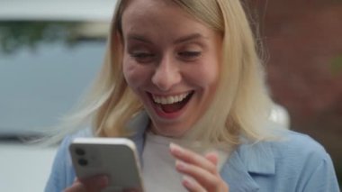 Mutlu, beyaz kadın, gülümseyen, bayan, neşeli, otomobil satıcısı, iş kadını parşömen ekranı, cep telefonu, akıllı telefon, otomobil sürücüsü, şehir otomobili, iyi haberler, araba kirası.