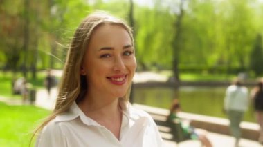 Mutlu Avrupalı kadın dişçi gülümsemesi keyif verici park keyfi başarılı sarışın kız başarılı iş kadını öğrenci gülen şehir kamerası şehrine duygusal olarak bakıyor.