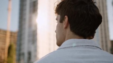 Kafkasyalı bir adamın başını döndürüp gülümsemesi mutlu, neşe dolu, çalışan, yönetici, girişimci, erkek, işadamı iş adamı, güler yüzlü bir şekilde şehir merkezinde dikildiğini düşünmesi.