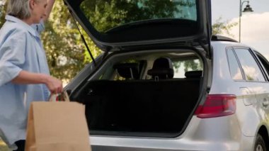 Yaşlı, yaşlı, beyaz, yaşlı, yaşlı, kadın, kadın, otomobil sürücüsü, müşteri, araba bagajı, araba bagajı, alışveriş mağazası, mağaza siparişi veriyor.