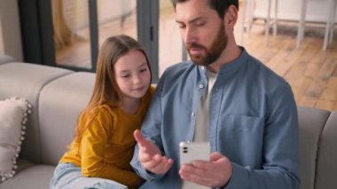 Mutlu bir aile, gülümseyen beyaz bir adam, baba evde küçük bir kızla konuşuyor. Babası, kızına cep telefonu cihazı kullanmayı öğretiyor. Babası, internetten yemek sipariş ediyor.