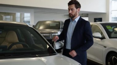 Beyaz adam müşteri alıcısı, tüketici salonu satın alıyor. Düşünen erkek adam, düşünceli iş adamı. Seçmeli otomobil otomobil otomobili, elektrikli taşıma, şüpheli, kafa yorucu iş adamı.