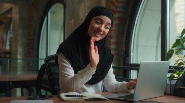 tesettürlü Arap müslüman kadın mutlu iş kadını bayan iş kadını sanal sohbet online dizüstü bilgisayar konferansı video selamlama, merhaba dost canlısı internet iletişimi gülümsemesi.