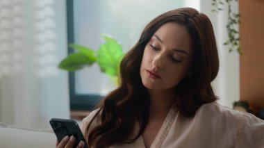 Beyaz kadın cep telefonlarını karıştırıyor akıllı telefonlara olumsuz cevap veriyor ev işkadınının evindeki cep telefonunda hayal kırıklığına uğramış kadın sohbet uygulaması üzgün üzgün üzgün üzgün üzgün üzgün hayal kırıklığı yaşıyor.