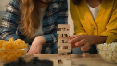 Çok ırklı çift çeşitliliği olan beyaz erkek, erkek, Afrikalı kadın, kadın, erkek, kadın, erkek, ev kanepede oyun oynayan karı, koca, kız arkadaş, ahşap bloklar inşa eden eğlenceli alkış.