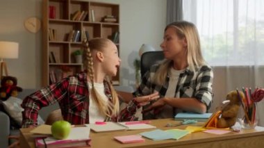 Mutlu kaygısız beyaz aile aktif liseli kız çocuğu ev masasında şarkı söylüyor anne küçük kız dans ediyor anne kız çocuk bakımı yapıyor neşeli bir tatil gülümsüyor
