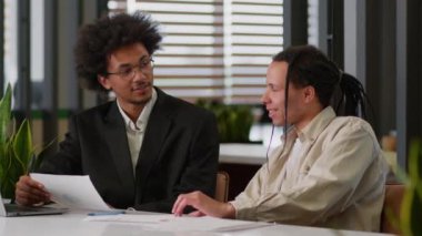 İki çok ırklı iş adamı Afrikalı Amerikalı iş adamları çeşitli iş arkadaşları erkekler mali verileri analiz ederler pazarlama projesi raporları ofis masasında dizüstü bilgisayar konuşmaları kullanırlar.