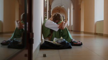 Kafkasyalı üzgün yalnız, endişeli kız öğrenci kız öğrenci çocuk çocuk ergen öğrenci koridorda oturuyor okul üniversitesinde zorbalığa maruz kalıyor ve sorun eğitimi öğreniyor.