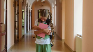 Hüzünlü genç kız öğrenci öğrenci öğrenci öğrenci, yalnız çocuk okulu akademisi salonunu altüst etti. Yalnız başına kameraya baktı.