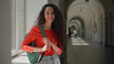 Mutlu, güler yüzlü Latin kadın üniversite akademisi koridorunda öğrenci kız öğrenci. Eğitime davet edildin, eğitime davet edildin. Hoş geldin jesti öğrenmeyi karşıla.