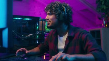 Hintli Müslüman adam video oyunu oyuncusu siber spor erkek klavyeci bilgisayar adamı radyo sunucusu bağımlı kulaklıklar radyo blogcusu ses kaydedicisi yayın monitörü bağırıyor sanal ağ oyunu