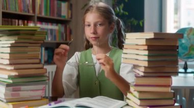 Sevimli, sevimli, gülümseyen, beyaz kız, liseli kız öğrenci, gözlüklü, gözlüklü, gözlüklü, ödevlerini hazırlayan, sınıf eğitiminde ders çalışan öğrenci.