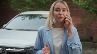 Gülümseyen Kafkasyalı kadın nakliyeci kadın müşteri cep telefonuyla konuşuyor. Şehirdeki akıllı telefon görüşmeleri. Kadın sürücü, kiralık iş kadını satın almaktan bahsediyor.