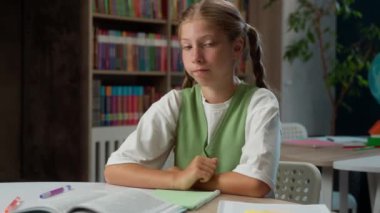 Kafası karışmış küçük beyaz kız çocuk liseli kız... güvensiz öğrenci... ev ödevi yapıyor... eğitim öğreniyor... kamera karşısında omuz silkiyor... kapalı alanda el hareketi yapıyor.