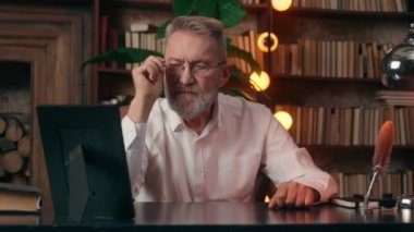 Kafkasyalı yaşlı bir adam çerçeveli fotoğrafı inceliyor. Düşünen bir emekli iş adamı evinde nostalji yapıyor. Yaşlı bir erkek, gözlüklü fotoğraf ofisinin hafızasını çıkarıyor.