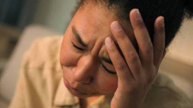 Hüzünlü üzgün Afrikalı Amerikalı kadın üzgün surat ifadesi olan kız baş ağrısı çekiyor. Sağlık sorunları var. Hüzünlü kadın ağrısı, evde ağlama, endişeli panik atak.