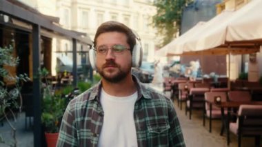 Kafkasyalı rahat bir adam, kulaklıklı, müzik kulaklıklı, turist, kaygısız, şarkı listesindeki, telefon çalma listesindeki, şehir dışına çıkan, kulaklıklı, gülen bir iş adamı.